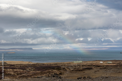 Scenery with dark clouds and rainbow over the raw coast of Snaefellsnes peninsula, Iceland