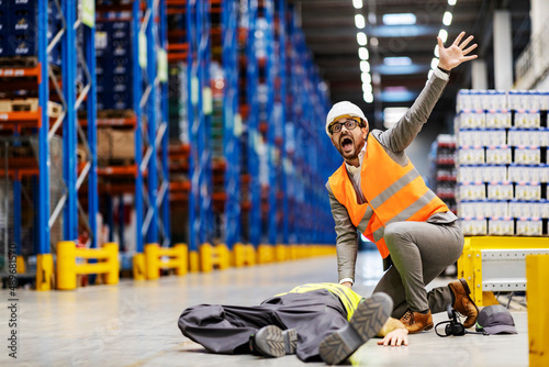 A scared inspector screaming for help for his injured laying worker at warehouse.