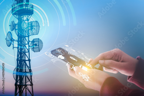 Fotografia Woman using mobile smartphone and Telecommunication tower Antenna, Communication technology network, Internet connection, social media, technology icons on virtual screen, Internet of Things IoT