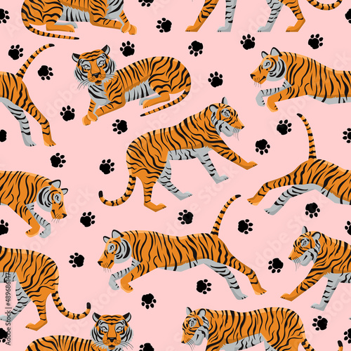Seamless pattern with funny tigers and paw prints on a pink background. Animal template with striped wild animals. Trendy background for textiles and fabrics. Vector illustration.