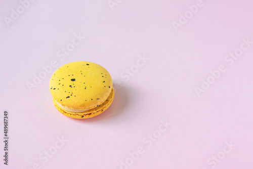 Yellow macaron on pink background, french dessert