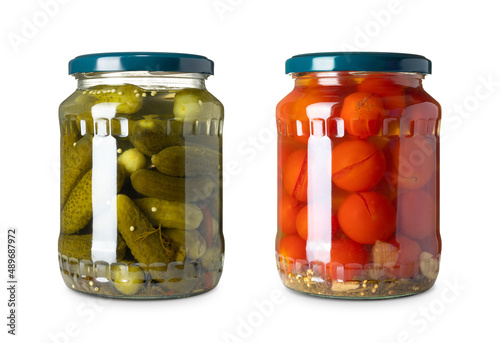 The two glass jar with cucumbers and tomatoes on a white background