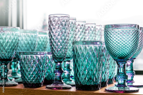 Green aquamarine goblets and glasses for wine in the store on the counter transparent set collection embossed