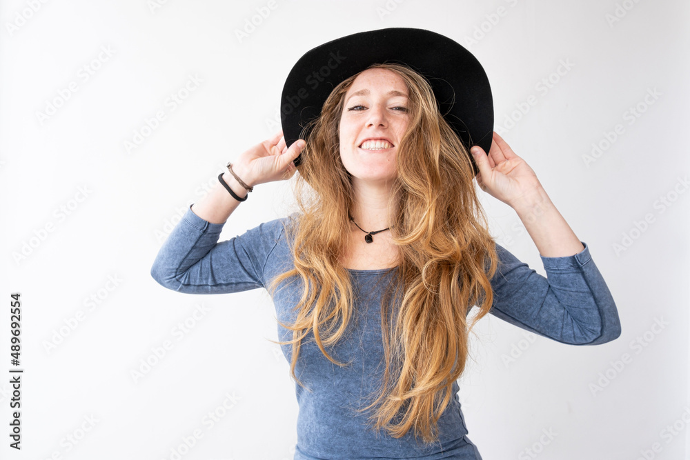 A woman is smiling and feeling happy with her cap. She is looking at the camera, down or up. She is taking her long hair. A woman is smiling and feeling happy with her cap. She is looking at the camera, down or up. She is taking her long hair.