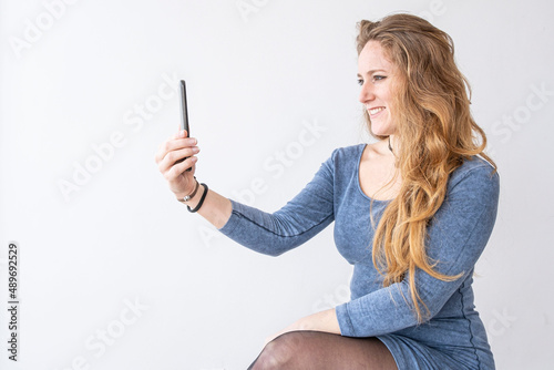 A sit woman is taking a selfie.