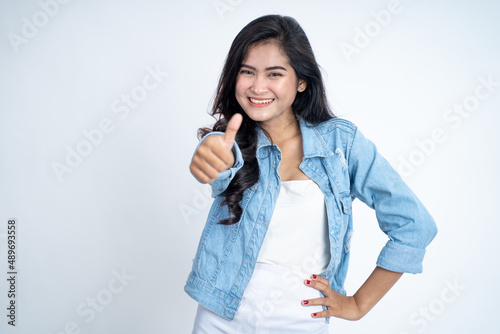 attractive young woman stand with thumbs up on isolated background