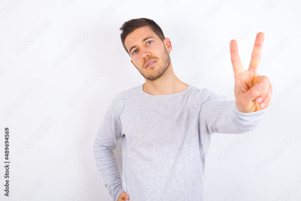 young caucasian man wearing grey sweater over white background directs fingers at camera selects someone. I recommend you. Best choice young caucasian man wearing grey sweater over white background directs fingers at camera selects someone. I recommend you. Best choice