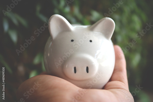 Working man holding piggy bank carefully, saving money for retirement concept.