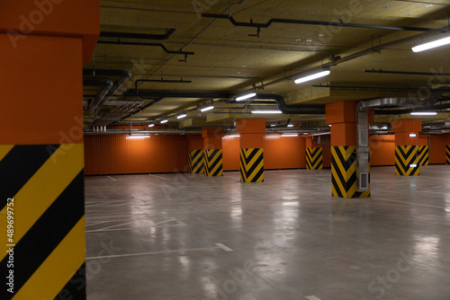 Underground parking in a mall, soft focus. Empty mall underground parking lot or garage interior with painted concrete columns. parking without cars. 