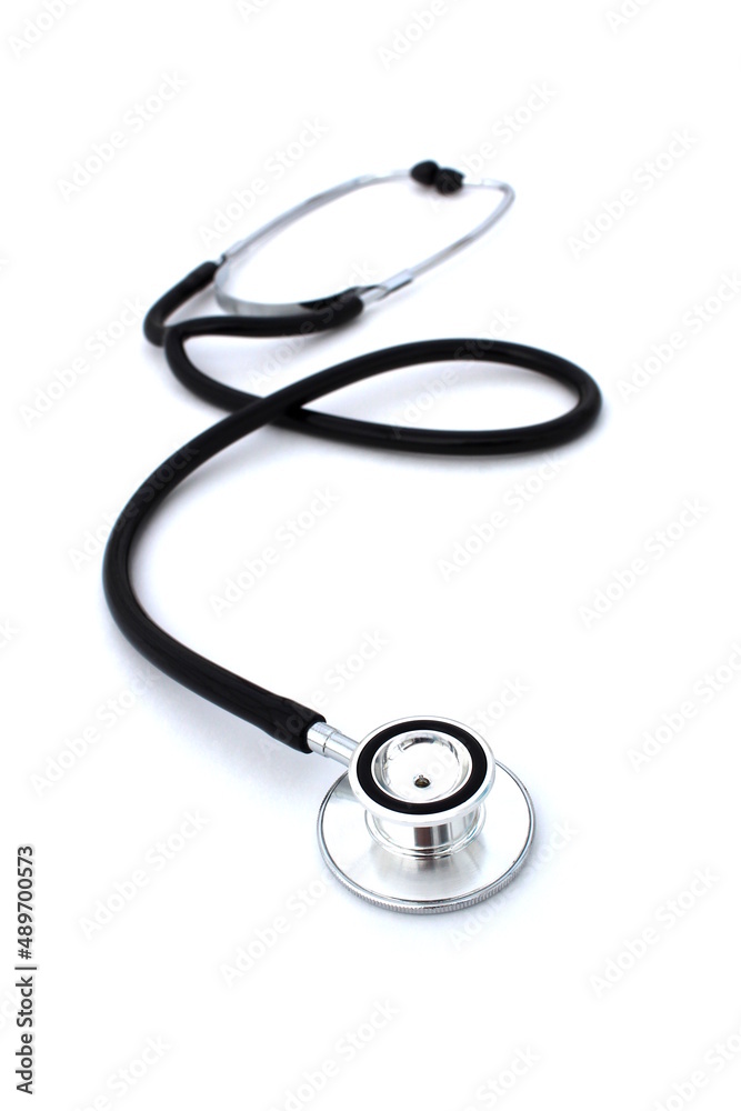 On a white isolated background lies a black stethoscope. On a white isolated background lies a black stethoscope.