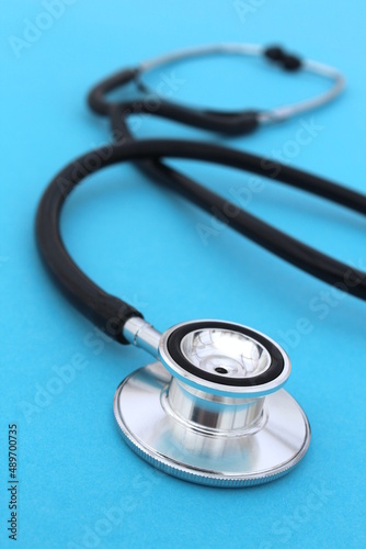  The stethoscope lies on a blue bright background.