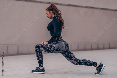 Fashion fitness model doing workout and posing outside.