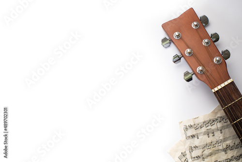 Closeup of guitar headstock with dummy musical score in white background, Banner, Overhead with copy space
