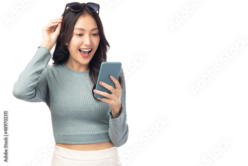 Happy and excited young woman using mobile phone standing over isolated on white background and copy space Young girl using smartphone for shopping online chat and texting message She get surprised