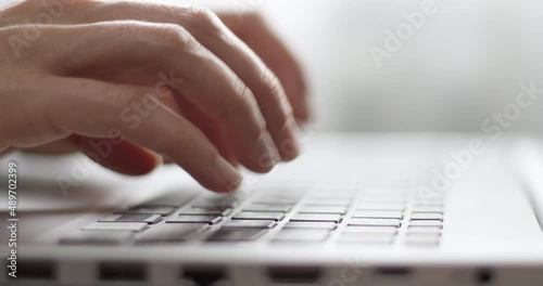 Hands typing on a laptop keyboard, close-up. photo