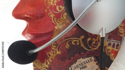 Mund- und Nasenbereich einer Venedig-Maske aus Pappmaché, ein Headset tragend, seitliche Perpektive photo