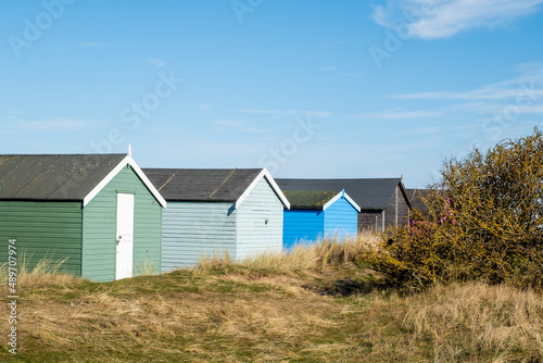 Traditional wooden beach hut in the sand dunes on a bright and sunny day on Hunstanton beach, North Norfolk coast.