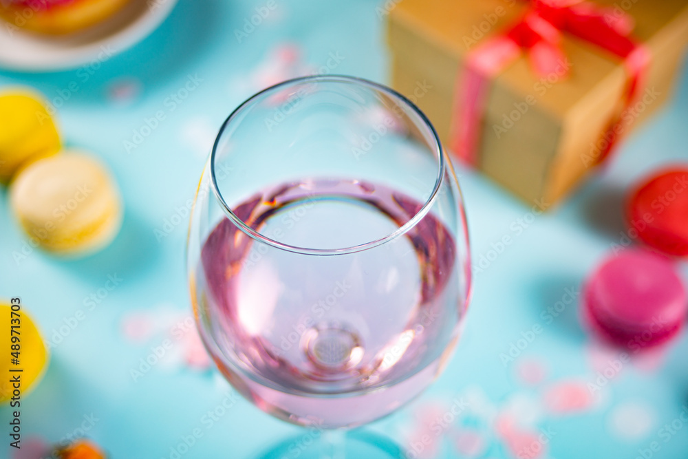 Glass of pink rose wine with donut, macaroons and gift box. Romantic style. Valentines day concept. Glass of pink rose wine with donut, macaroons and gift box. Romantic style. Valentines day concept.