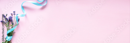 Banner. Bouquet of lavender tied with a blue ribbon on a pink background. Flat layout. Minimalism