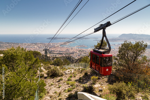 Arrivée de la cabine rouge d'un téléphérique au-dessus d'une grande ville portuaire sur la méditerranée. Téléphérique du Mont Faron, Toulon photo