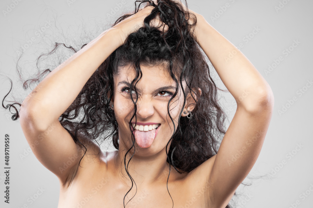 Beautiful brunette girl with long wet hair, studio portrait. Funny face expression Beautiful brunette girl with long wet hair, studio portrait. Funny face expression