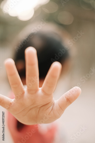 The little girl's hand gesture with open fingers shows refuse