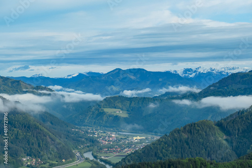 Panoramic view on the Eisenerzer Alps from below mount Roethelstein near Mixnitz in Styria, Austria. Snow capped mountain of the Ennstal Alps beyond the Grazer Bergland in Styria, Austria. Village photo