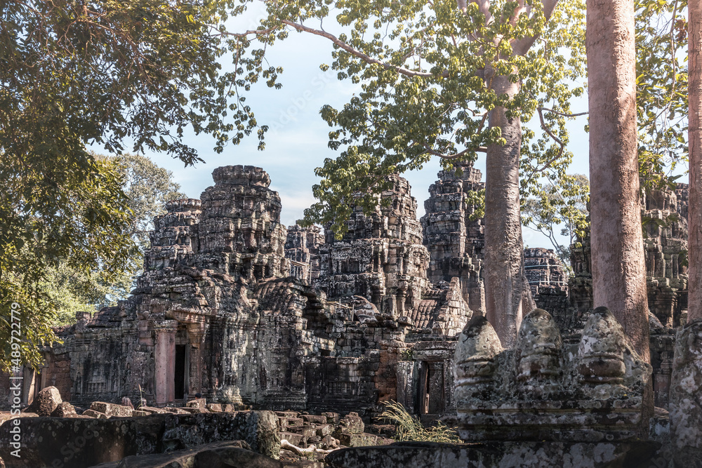 Ruins of ancient Cambodian temple among trees in Angkor complex, Siem Reap, Cambodia