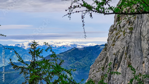 Massive rock formation and a scenic view from below mount Roethelstein near Mixnitz in Styria, Austria. Snow capped mountain of the Ennstal Alps beyond the Grazer Bergland in Styria, Austria. photo