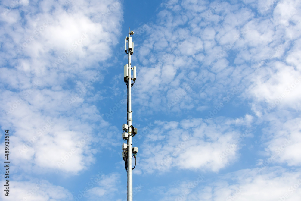 Cellular macro Base Transceiver Station. Telecommunication tower. Wireless Communication Antenna Transmitter. Development of communication systems in urban area blue sky.