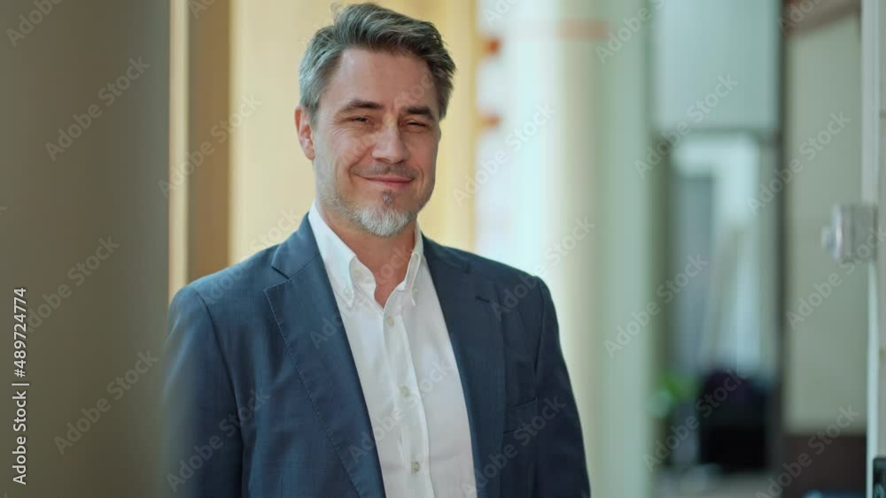 Business portrait - confident businessman standing in office. Happy mid adult man in shirt and jacket, smiling. Bearded, gray hair. Business portrait - confident businessman standing in office. Happy mid adult man in shirt and jacket, smiling. Bearded, gray hair.