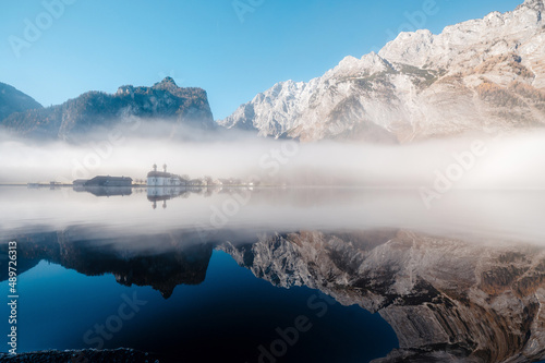 Morning fog over church St. Bartholomew on Konigsee lake photo