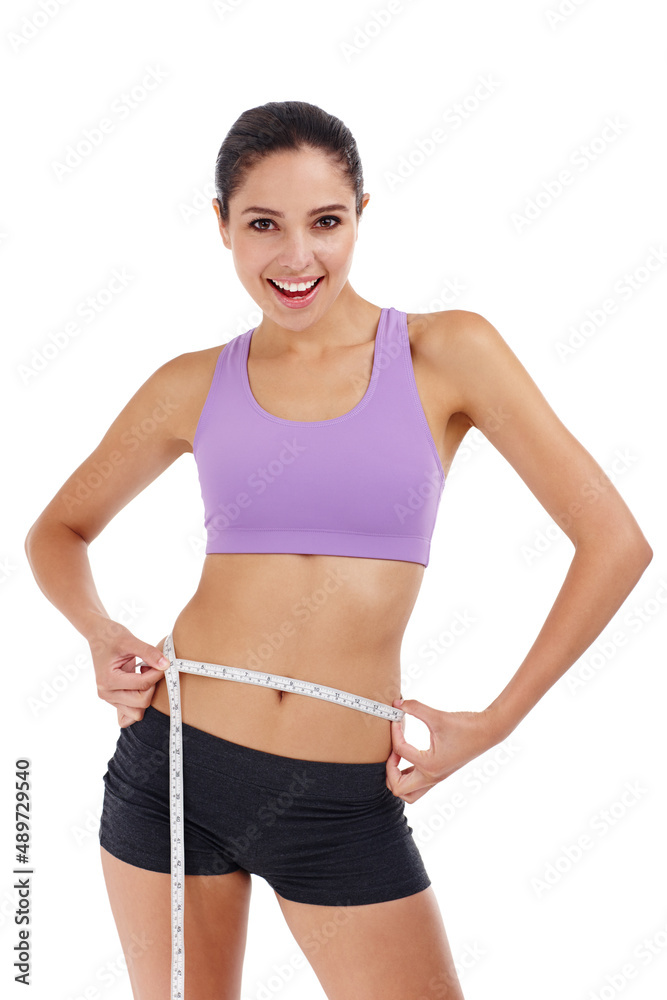 Slimming down for summer. Three quarter length shot of an attractive young woman in gym clothes measuring her waist. Slimming down for summer. Three quarter length shot of an attractive young woman in gym clothes measuring her waist.