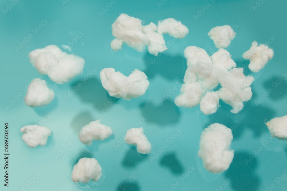 White cotton fake clouds on a pastel blue background. White cotton fake clouds on a pastel blue background.