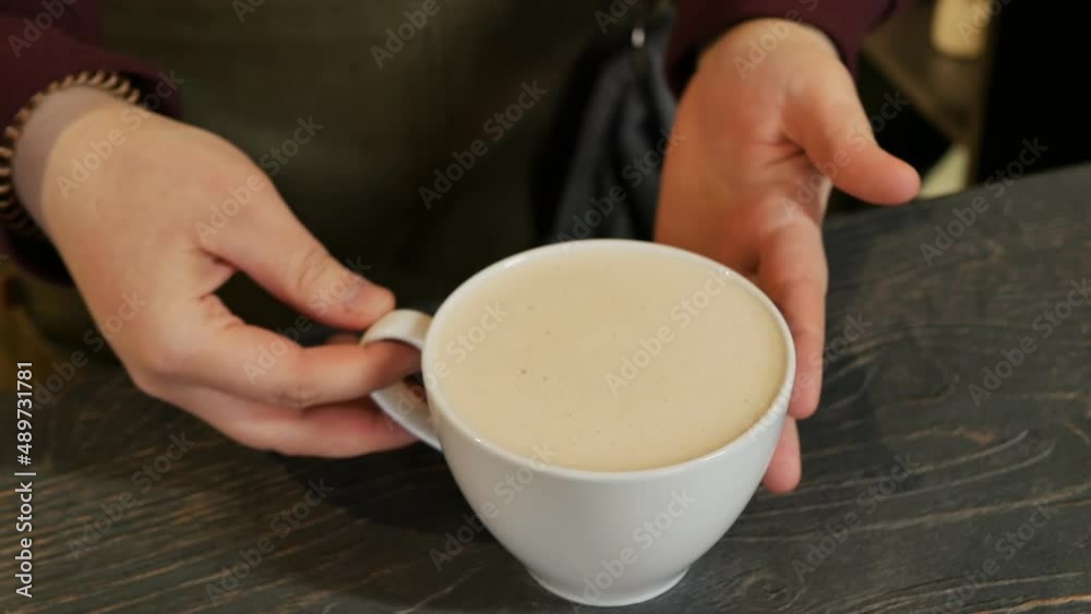 the hands of the barista gently and carefully took a cup of cappuccino and carried it away to the client. Submission of an order in a cafe the hands of the barista gently and carefully took a cup of cappuccino and carried it away to the client. Submission of an order in a cafe