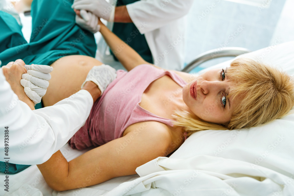 Obraz premium Woman giving birth in hospital with medical doctor team