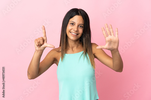 Caucasian girl isolated on pink background counting seven with fingers