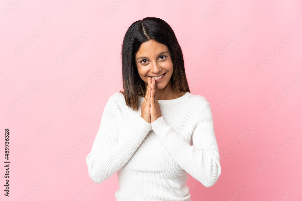 Caucasian girl isolated on pink background keeps palm together. Person asks for something Caucasian girl isolated on pink background keeps palm together. Person asks for something