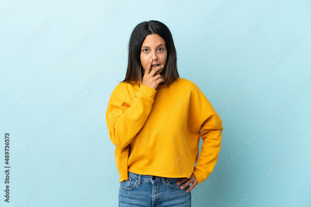 Caucasian girl isolated on blue background surprised and shocked while looking right Caucasian girl isolated on blue background surprised and shocked while looking right