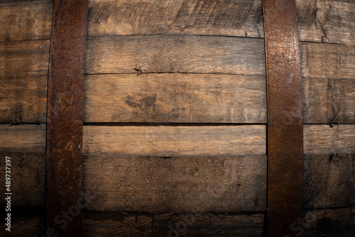 Old wooden barrel texture background. Wine or beer cask close up. Weathered, aged, rusty, vintage container in brewery cellar. Copy space for design