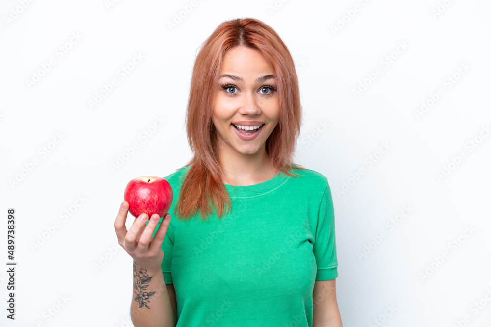 Young Russian girl with an apple isolated on white background with surprise and shocked facial expression Young Russian girl with an apple isolated on white background with surprise and shocked facial expression