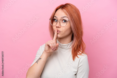 Young Russian girl isolated on pink background With glasses and doing silence gesture