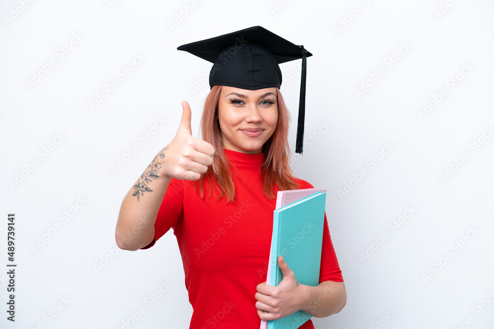 Young student Russian girl isolated on white background with thumbs up because something good has happened Young student Russian girl isolated on white background with thumbs up because something good has happened