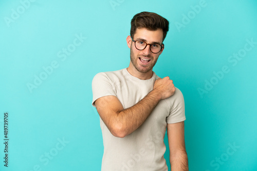 Young caucasian handsome man isolated on blue background celebrating a victory