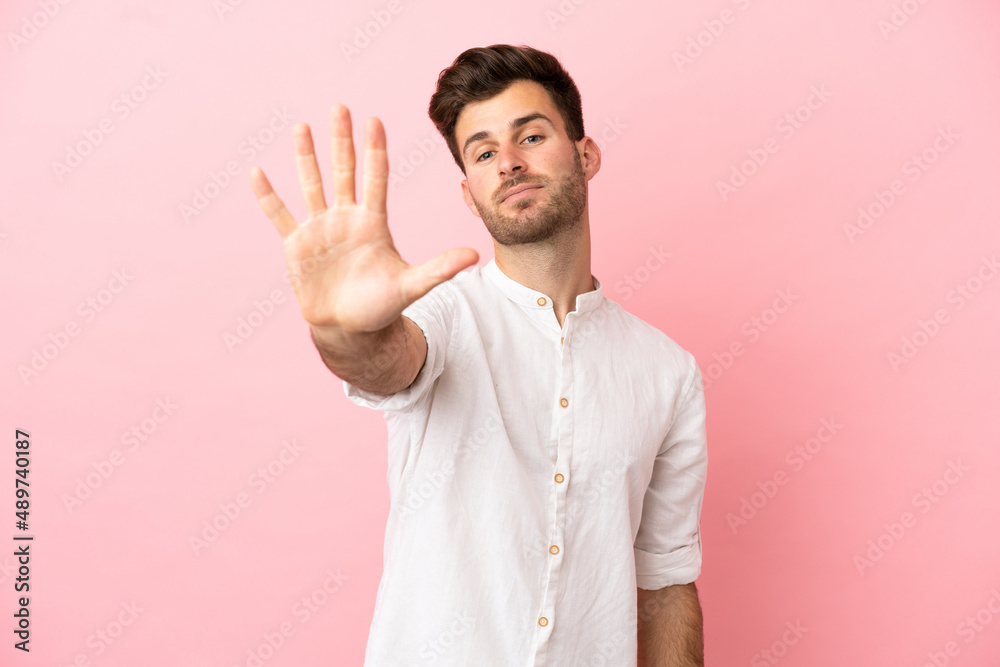 Young caucasian handsome man isolated on pink background counting five with fingers Young caucasian handsome man isolated on pink background counting five with fingers