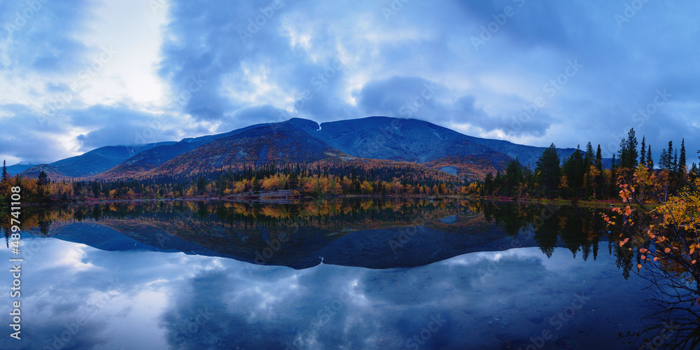 Reflection of mountains and clouds in the calm surface of the lake. Peaceful landscape. Khibiny
