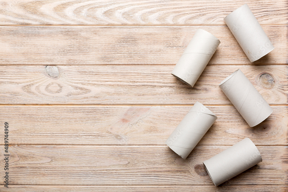 Flat lay composition with empty toilet paper rolls and space for text on color background. Recyclable paper tube with metal plug end made of kraft paper or cardboard Flat lay composition with empty toilet paper rolls and space for text on color background. Recyclable paper tube with metal plug end made of kraft paper or cardboard