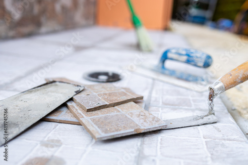 Renovation bonus, super bonus 110%, worker busy renovating the house, taking advantage of the state bonus. Various types of tools are arranged on a table or on the floor.