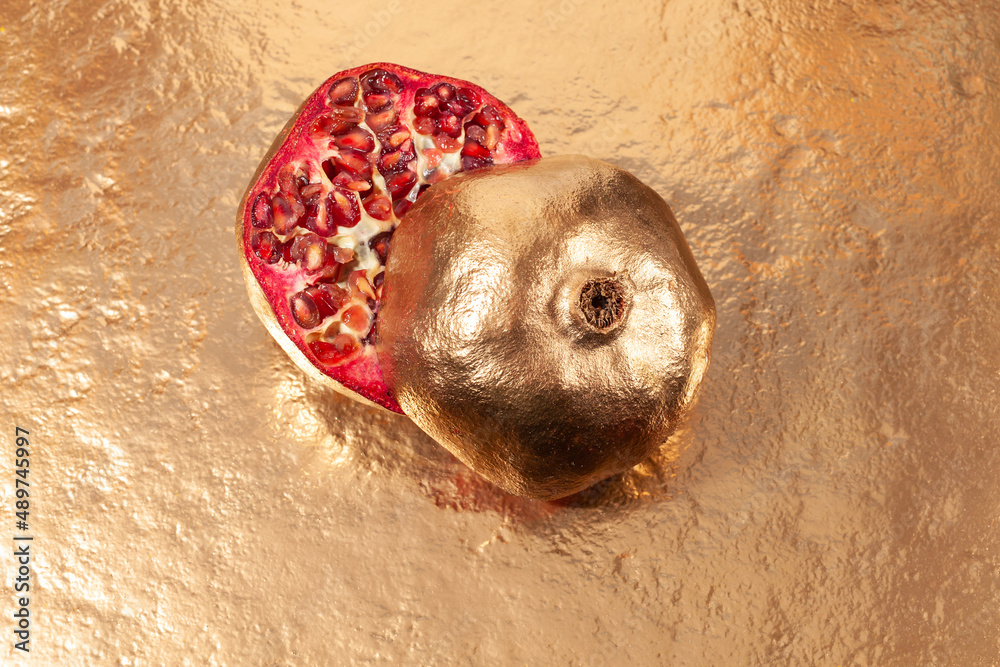 golden pomegranate fruit on gold background golden pomegranate fruit on gold background