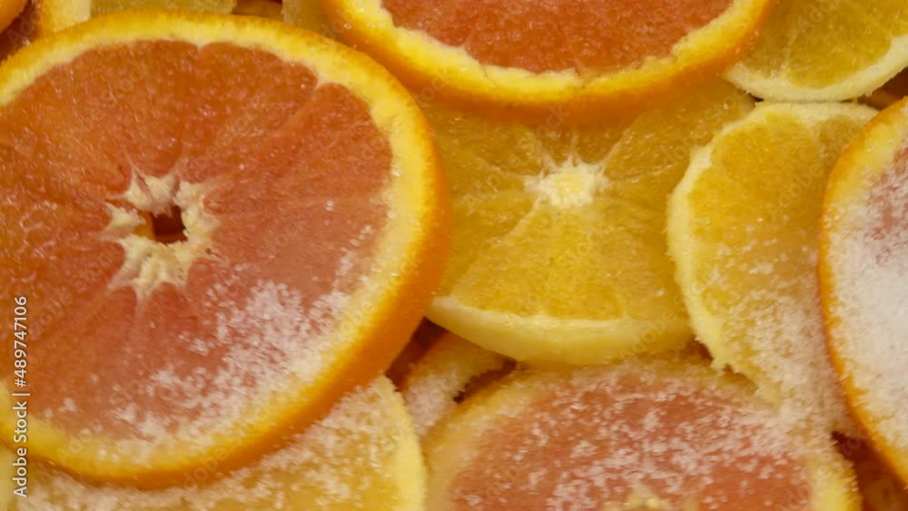 Orange slices sprinkled with sugar lie in layers in a copper basin for making jam. Orange slices sprinkled with sugar lie in layers in a copper basin for making jam.